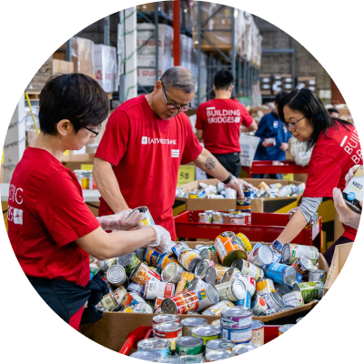 East West Bank employees sorting can food at a community charity event.