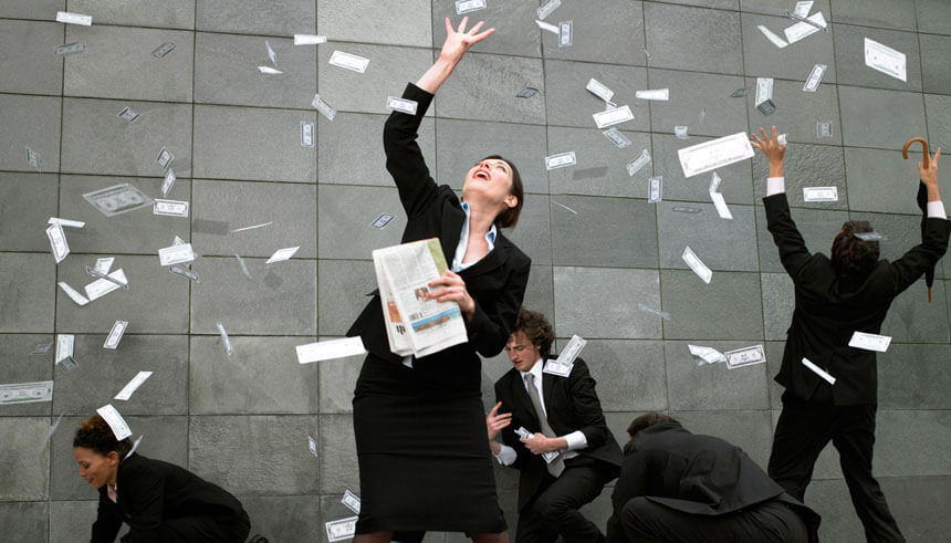Business people on pavement catching falling money