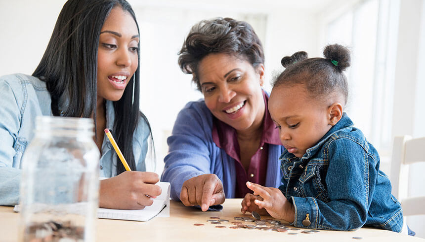 Family counting coins, thus teaching their child financial literacy