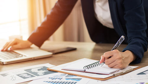 Hands of a small business owner who takes notes about SBA loans