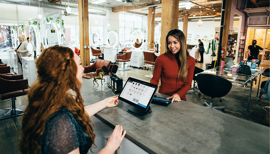 cashier behind the counter greeting a customer ready for transaction