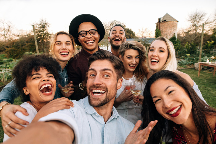 A group of people smile and take a selfie together.