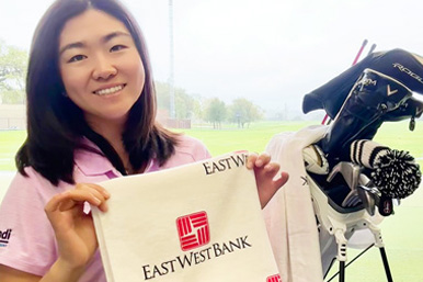 Rose Zhang holding a bag with East West Bank logo.