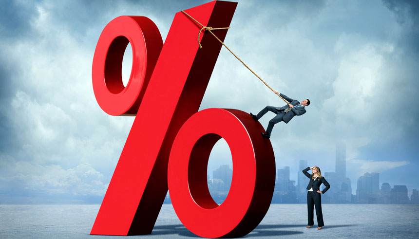 Businesswoman watches a businessman use a rope to climb a large percentage sign representing the growing interest rates