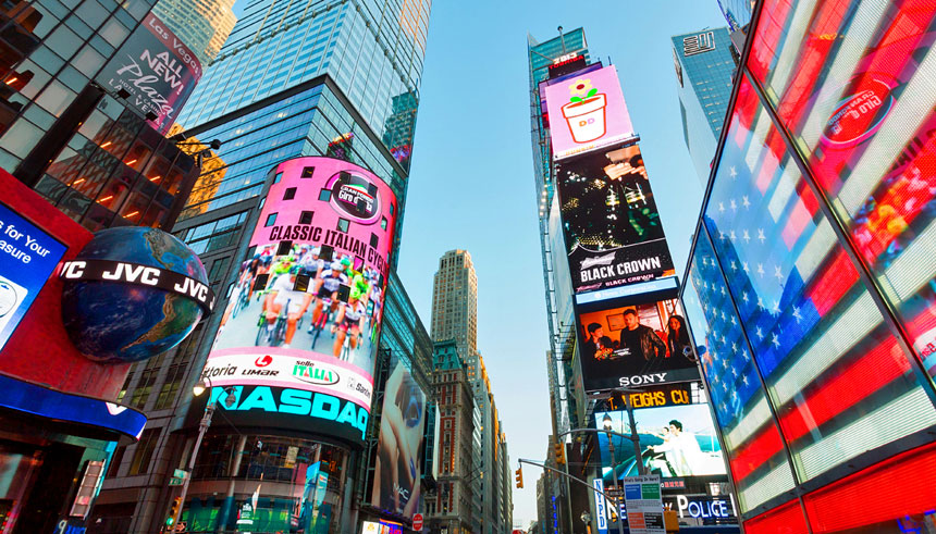 New York City Times Square at dusk with lit up billboards of global brands 