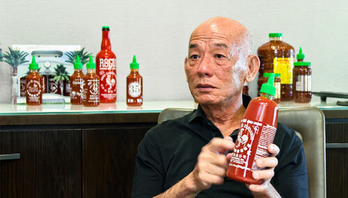 匯豐食品CEO陳德正在介紹是拉差辣椒醬包裝上的公雞標誌