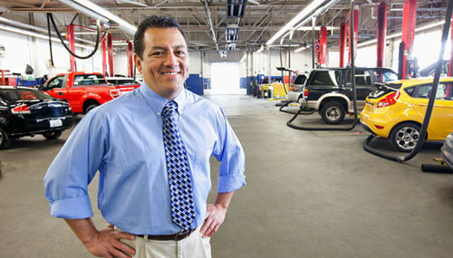 A small business owner standing in his auto shop