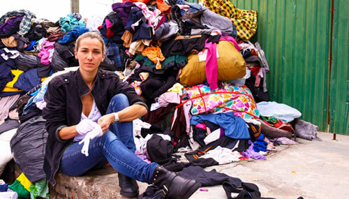 Christina Dean, founder and board chair of Redress, is sitting next to a pile of clothes