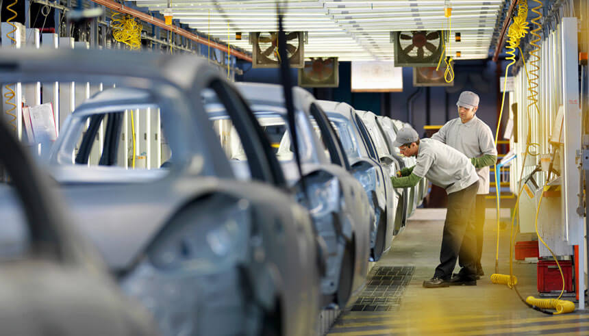Car plant workers on production line
