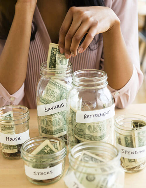 Woman putting money in retirement jar