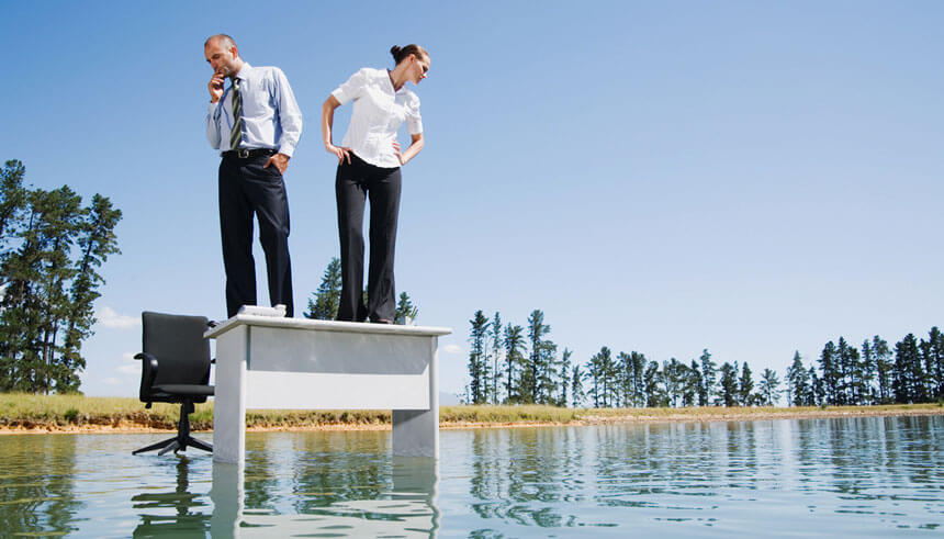Businesswoman and man standing on a desk on water