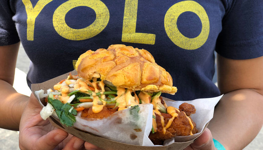 Tsz Chan, founder of Bolo, holding Bolo fried chicken sandwhich 