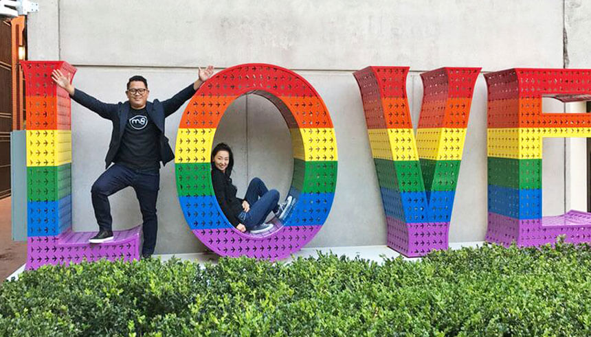 Stephen Liu y su esposa Linda, cofundadores de la aplicación de citas M8, en un letrero que dice LOVE