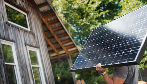 A man carrying a solar panel