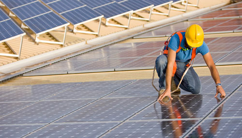 Worker on the rooftop installing solar panel