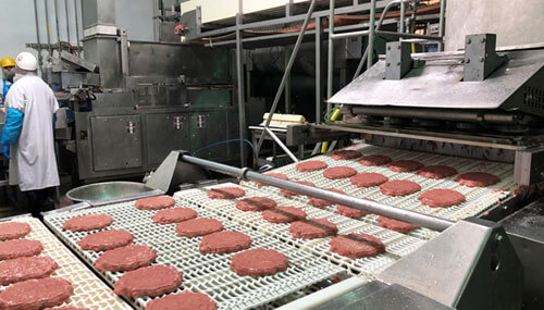 Meat patty conveyor belt at ProPortion Foods