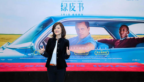 Wei Zhang standing in front of Green Book poster in Chinese