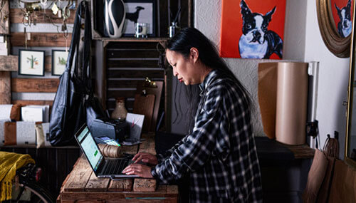 女性企業家在自己的精品店中使用筆記型電腦