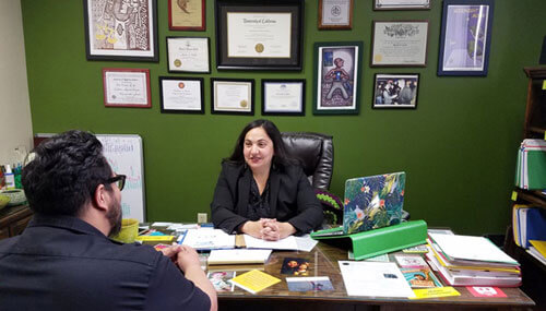 La abogada Mercedes Castillo ayudando a un cliente en su escritorio