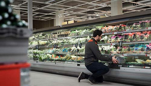 Hombre en un supermercado escogiendo productos