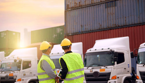 Two workers standing outside of a warehouse