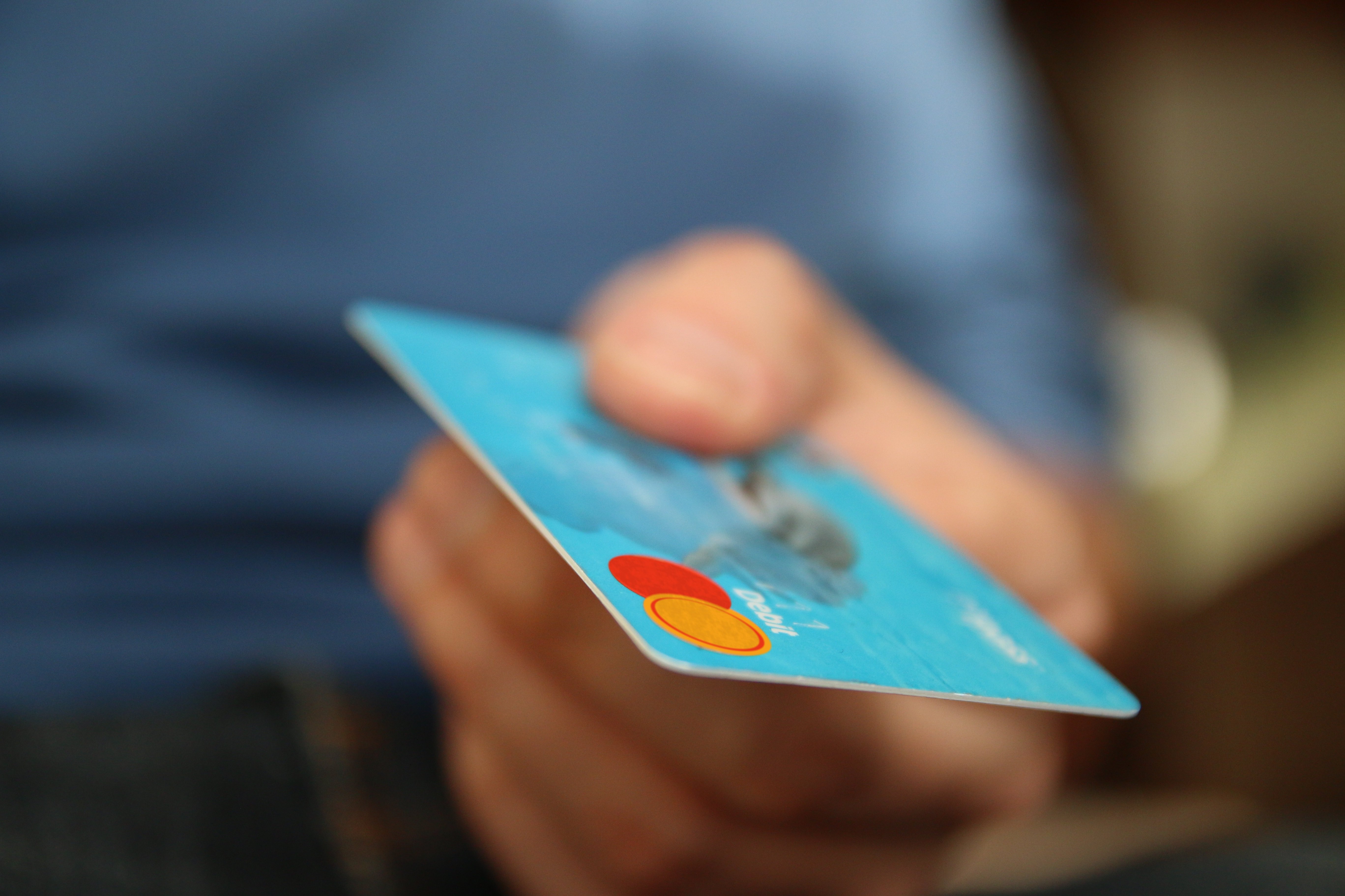 a hand showing a blue credit card